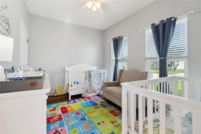 bedroom featuring ceiling fan and a crib