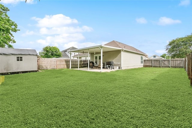 view of yard with french doors, a storage shed, an outdoor structure, a fenced backyard, and a patio