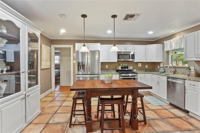 3705 Clifford Dr, Metairie, LA 70002 - kitchen with ornamental molding, white cabinetry, a sink, decorative light fixtures, and stainless steel appliances
