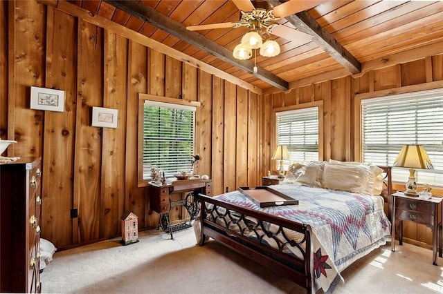 carpeted bedroom with beamed ceiling, wood walls, multiple windows, and wood ceiling