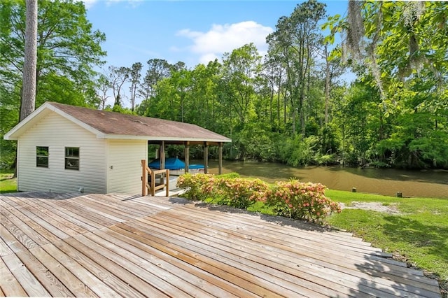 wooden terrace with a water view and a yard
