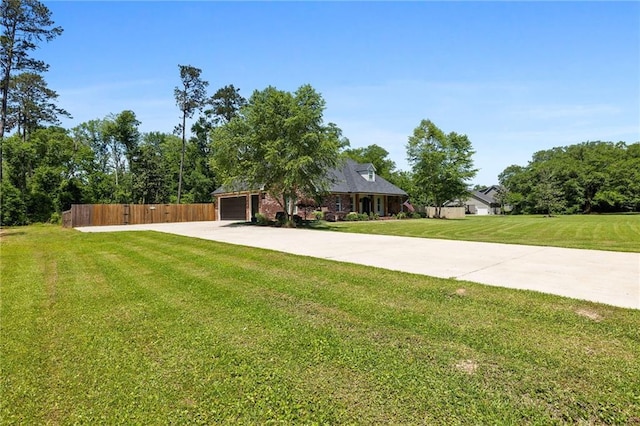 view of front of house with fence, a garage, driveway, and a front yard