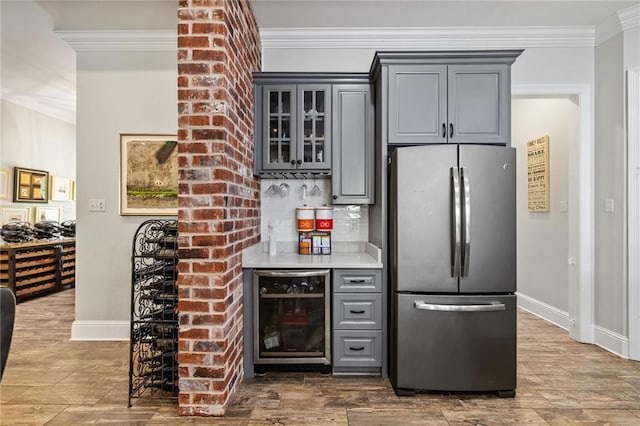 bar with crown molding, freestanding refrigerator, wine cooler, baseboards, and a bar