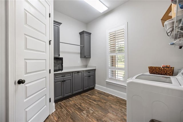 washroom with baseboards, dark wood-type flooring, cabinet space, and washer and dryer