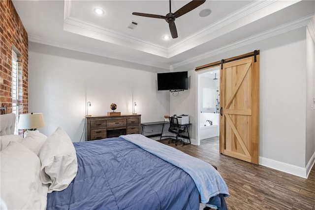 bedroom with baseboards, a barn door, crown molding, and wood finished floors
