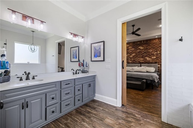 full bath with crown molding, a sink, ceiling fan with notable chandelier, and wood finished floors