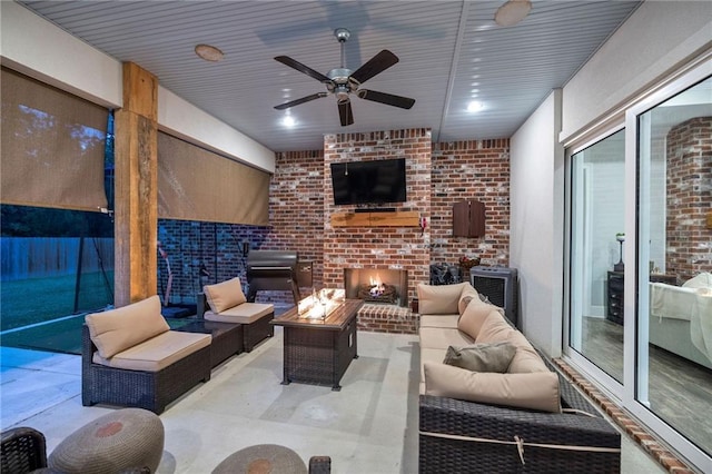 view of patio featuring a ceiling fan and an outdoor living space with a fireplace