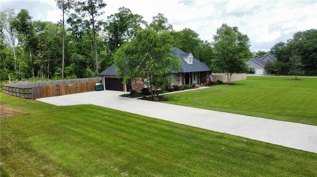 view of front of property featuring concrete driveway, an attached garage, fence, and a front lawn