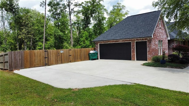 garage featuring fence, a gate, and concrete driveway