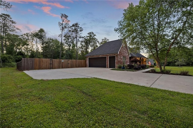 exterior space featuring fence, a lawn, driveway, and brick siding