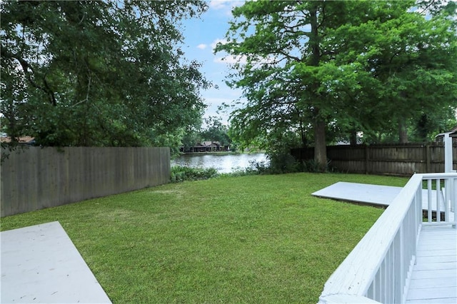 view of yard with a water view and a fenced backyard