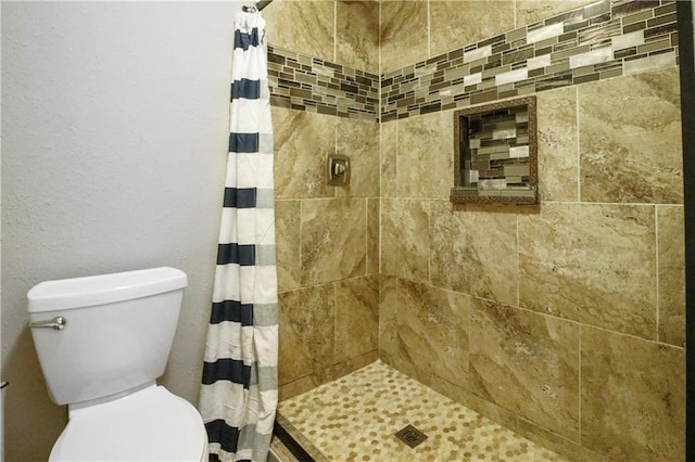 full bath with toilet and a tile shower