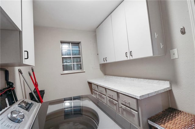 washroom with washer / clothes dryer and cabinet space