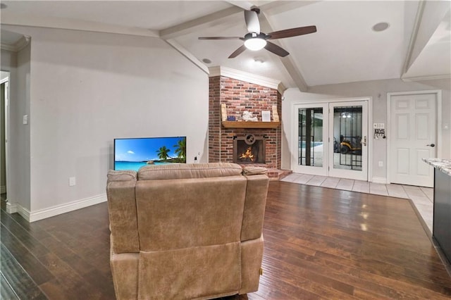 living area featuring a fireplace, baseboards, lofted ceiling with beams, hardwood / wood-style flooring, and a ceiling fan