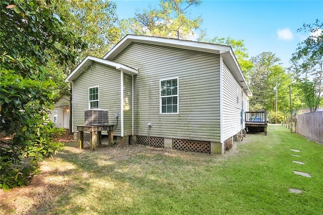 21221 Fern St, Covington, LA 70435 - back of property featuring a lawn, central AC unit, fence, and a deck