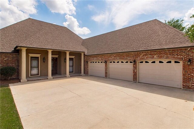14208 W Hoffman Rd, Hammond, LA 70403 - view of front of house featuring covered porch, roof with shingles, a garage, brick siding, and concrete driveway