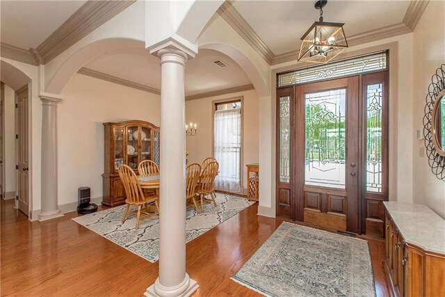 14208 W Hoffman Rd, Hammond, LA 70403 - foyer with arched walkways, an inviting chandelier, ornate columns, and wood finished floors