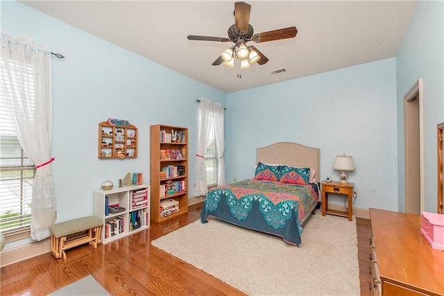 14208 W Hoffman Rd, Hammond, LA 70403 - bedroom featuring ceiling fan, visible vents, multiple windows, and wood finished floors