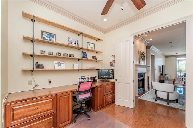 14208 W Hoffman Rd, Hammond, LA 70403 - office space featuring a ceiling fan, crown molding, a fireplace, built in desk, and light wood finished floors