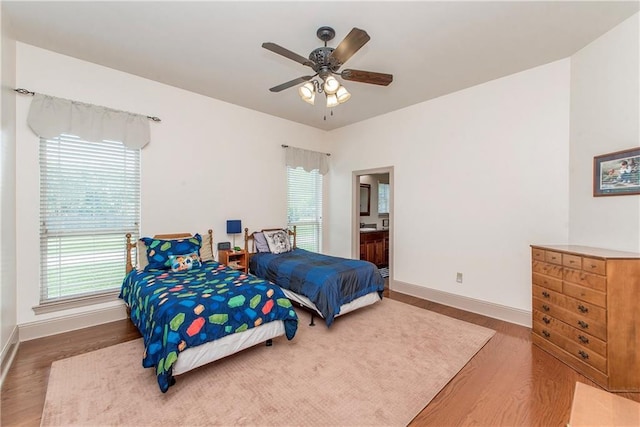14208 W Hoffman Rd, Hammond, LA 70403 - bedroom featuring baseboards, ceiling fan, wood finished floors, and ensuite bath
