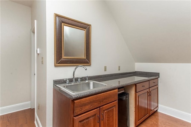 14208 W Hoffman Rd, Hammond, LA 70403 - kitchen featuring a sink, dark countertops, light wood-style floors, and brown cabinets