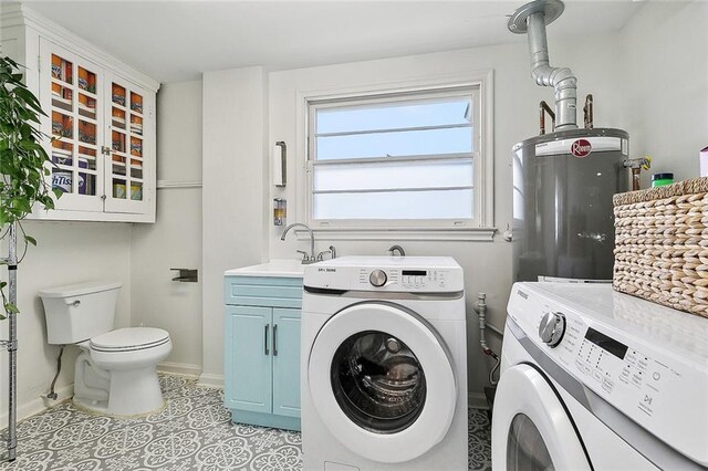 laundry area with laundry area, a sink, separate washer and dryer, light tile patterned floors, and electric water heater