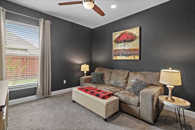 living room featuring baseboards, carpet flooring, and ceiling fan