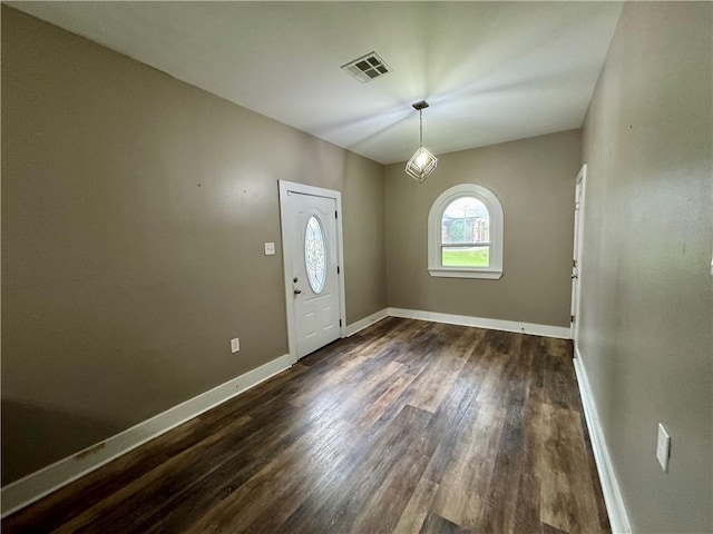 foyer entrance with baseboards, visible vents, and dark wood finished floors