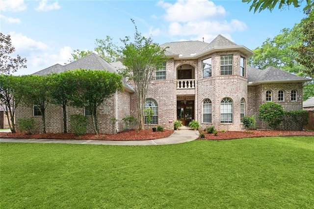 1045 Whitetail Dr, Mandeville, LA 70448 - french country inspired facade with a front lawn, brick siding, a balcony, and a shingled roof