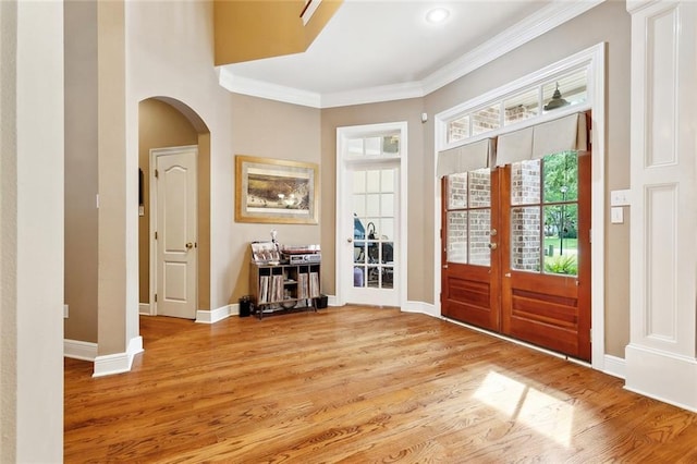 1045 Whitetail Dr, Mandeville, LA 70448 - foyer entrance with arched walkways, french doors, light wood-type flooring, baseboards, and healthy amount of natural light