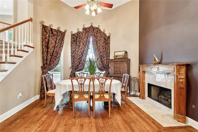1045 Whitetail Dr, Mandeville, LA 70448 - dining space featuring a ceiling fan, stairway, wood finished floors, baseboards, and a fireplace