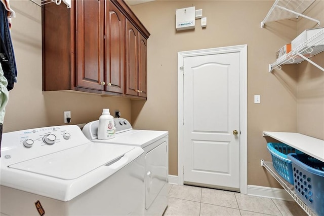 1045 Whitetail Dr, Mandeville, LA 70448 - laundry area with washing machine and clothes dryer, cabinet space, light tile patterned floors, and baseboards