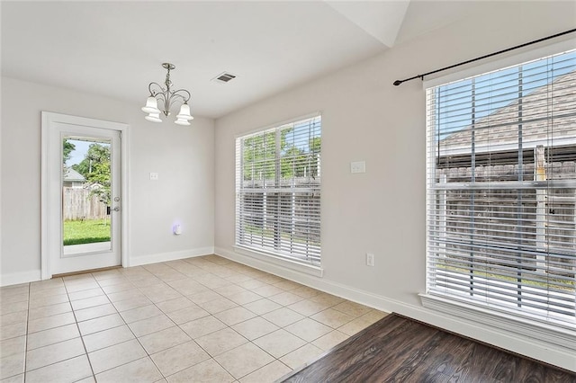 70363 10th St, Covington, LA 70433 - unfurnished dining area featuring visible vents, baseboards, light tile patterned floors, and a chandelier