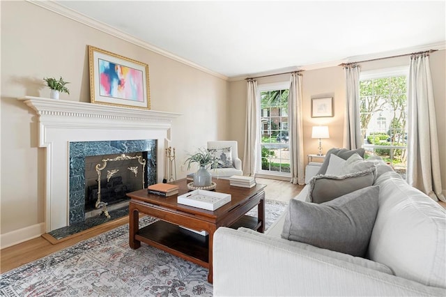living room featuring crown molding, baseboards, a healthy amount of sunlight, and wood finished floors