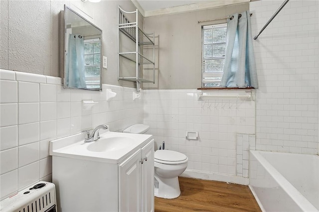 58420 Lynn Rd, Slidell, LA 70460 - full bath featuring toilet, tile walls, vanity, wood finished floors, and heating unit