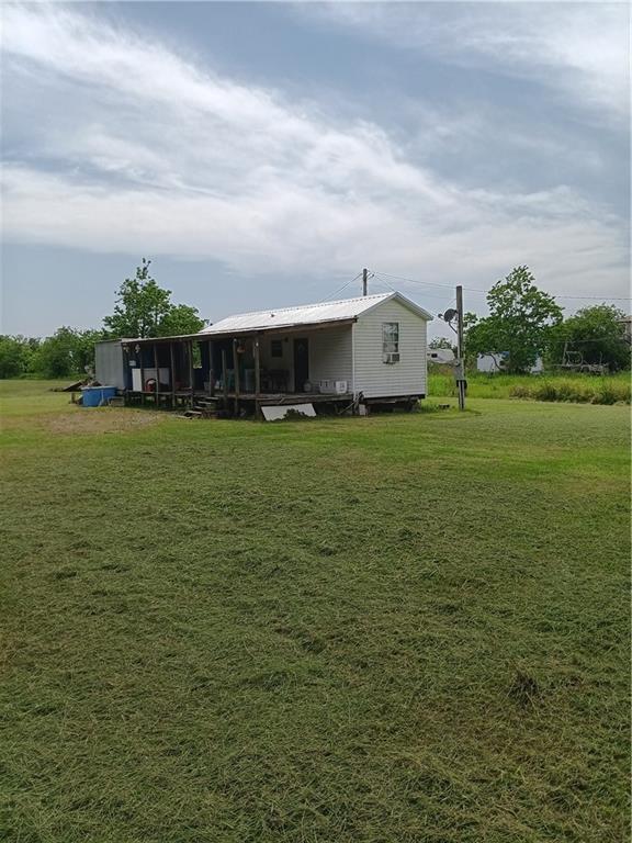 back of property featuring a yard and metal roof
