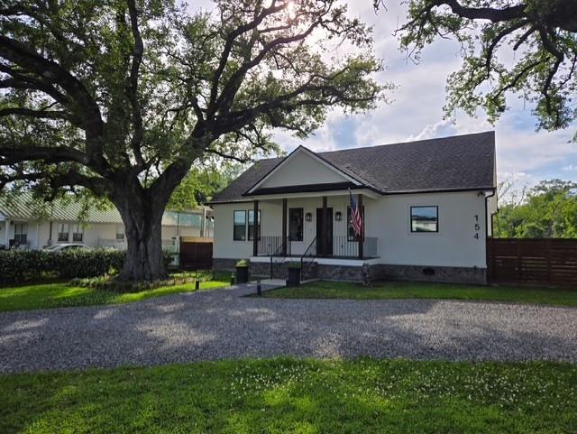 bungalow with covered porch, fence, and a shingled roof