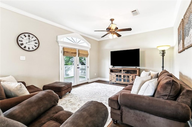 living room with visible vents, ornamental molding, wood finished floors, baseboards, and a ceiling fan