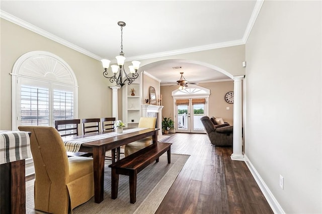 dining area with dark wood-type flooring, arched walkways, decorative columns, and ornamental molding