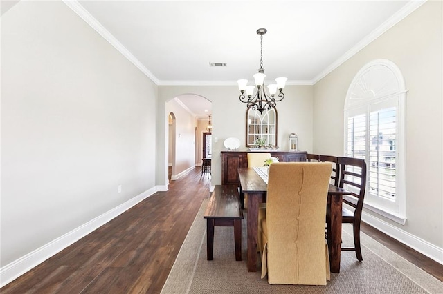 dining space featuring a notable chandelier, arched walkways, dark wood finished floors, baseboards, and visible vents