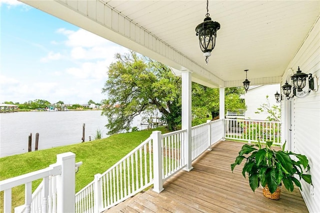 deck with a lawn, a water view, and a porch
