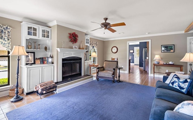 155 Greencrest Dr, Slidell, LA 70458 - living room featuring tile patterned flooring, a fireplace with raised hearth, a ceiling fan, baseboards, and ornamental molding