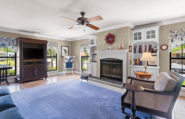 155 Greencrest Dr, Slidell, LA 70458 - living room with visible vents, crown molding, ceiling fan, a fireplace with raised hearth, and light tile patterned floors