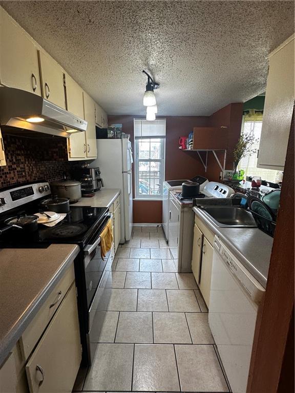 6320 Riverside Dr Unit 350, Metairie, LA 70003 - kitchen with stainless steel electric range oven, white dishwasher, under cabinet range hood, and plenty of natural light