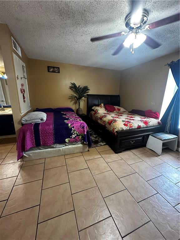 6320 Riverside Dr Unit 350, Metairie, LA 70003 - bedroom featuring visible vents, ceiling fan, a textured ceiling, a sink, and light tile patterned floors