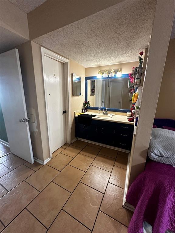 6320 Riverside Dr Unit 350, Metairie, LA 70003 - bathroom with a textured ceiling, baseboards, and vanity