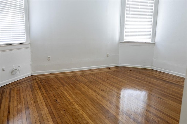 unfurnished room with baseboards and hardwood / wood-style floors