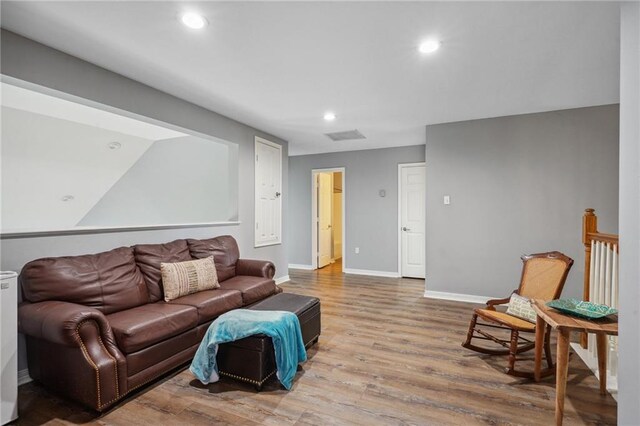 living area with recessed lighting, baseboards, visible vents, and wood finished floors