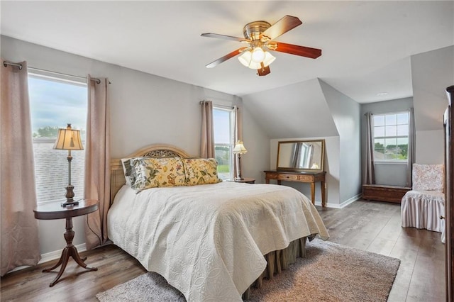bedroom featuring baseboards, ceiling fan, wood finished floors, and lofted ceiling