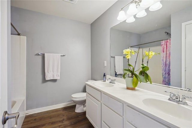 full bathroom featuring baseboards, a sink, wood finished floors, and toilet
